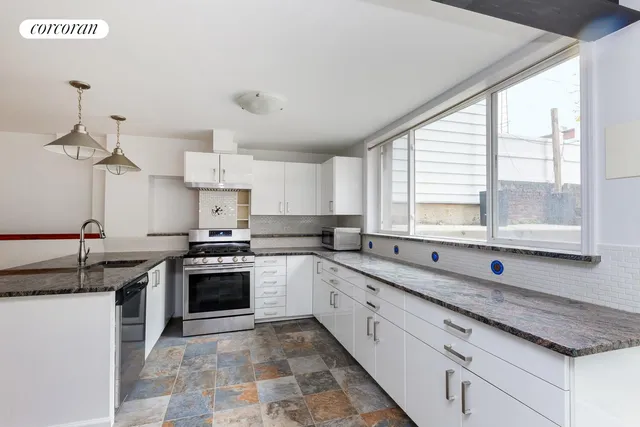a kitchen with stainless steel appliances granite countertop a sink and a stove