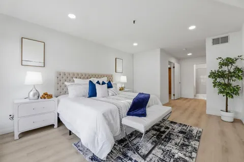 a bedroom with a bed and a potted plant