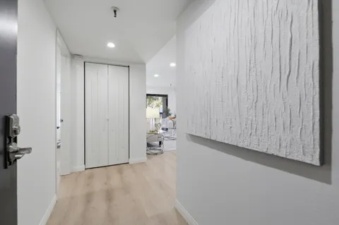 a view of an empty room and a kitchen