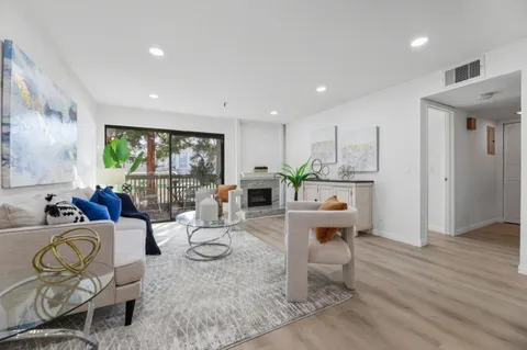a living room with furniture a wooden floor and a large window