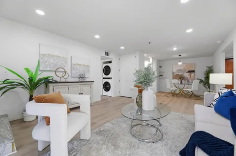 a dining room with furniture and potted plants