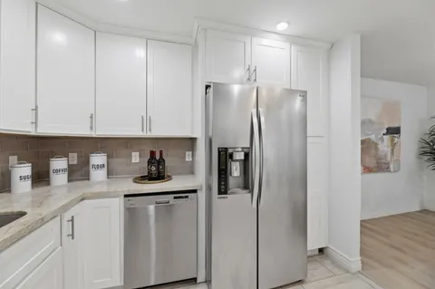 a kitchen with stainless steel appliances granite countertop a refrigerator and a sink