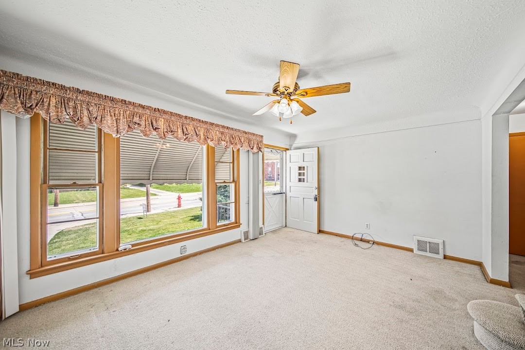 1738 Rockefeller Road Wickliffe, OH 44092 - Photo 16 of 35 Empty room with light carpet, ceiling fan, and a textured ceiling