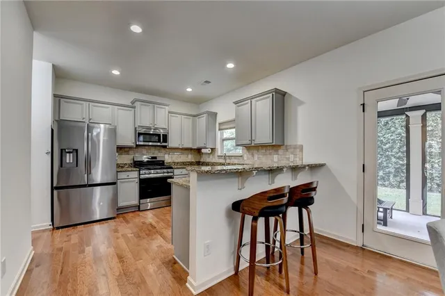 a kitchen with stainless steel appliances granite countertop a stove a refrigerator and a microwave