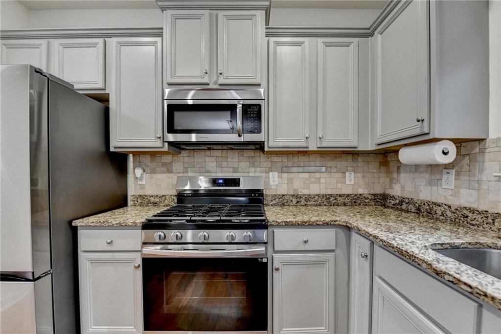 5013 Groover Drive Smyrna, GA 30080 - Photo 23 of 70 a kitchen with stainless steel appliances granite countertop a stove a refrigerator and a microwave