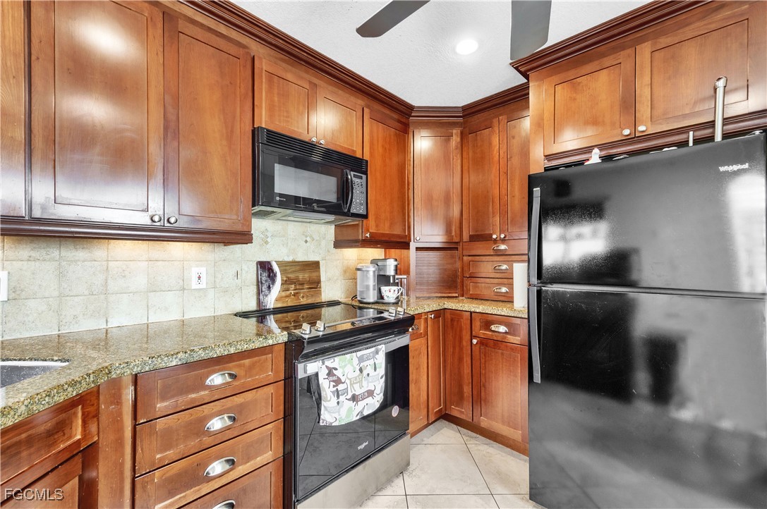 9141 Southwest 22nd Street, Unit F Boca Raton, FL 33428 - Photo 14 of 30 a kitchen with stainless steel appliances granite countertop a refrigerator stove and cabinets
