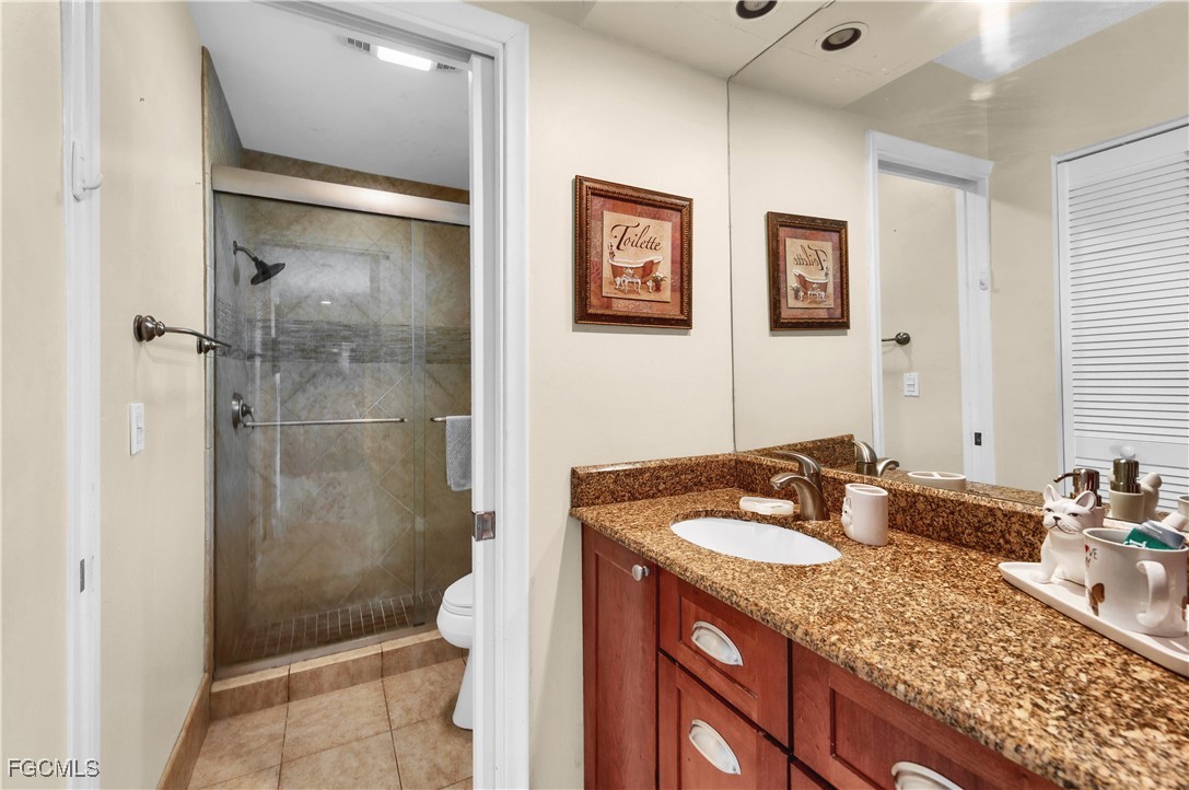 9141 Southwest 22nd Street, Unit F Boca Raton, FL 33428 - Photo 16 of 30 a bathroom with a granite countertop sink mirror and shower