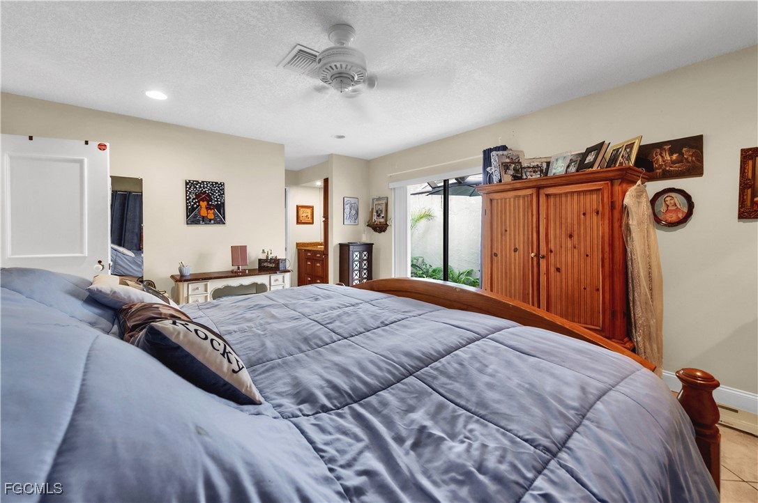 9141 Southwest 22nd Street, Unit F Boca Raton, FL 33428 - Photo 17 of 30 a bedroom with a large bed and a chandelier