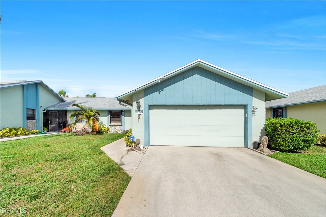 9141 Southwest 22nd Street, Unit F Boca Raton, FL 33428 - Photo 2 of 30 a front view of a house with a yard and garage