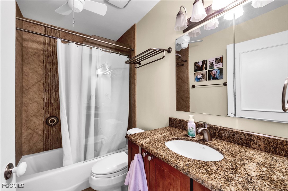 9141 Southwest 22nd Street, Unit F Boca Raton, FL 33428 - Photo 22 of 30 a bathroom with a granite countertop sink toilet a mirror a vanity and shower