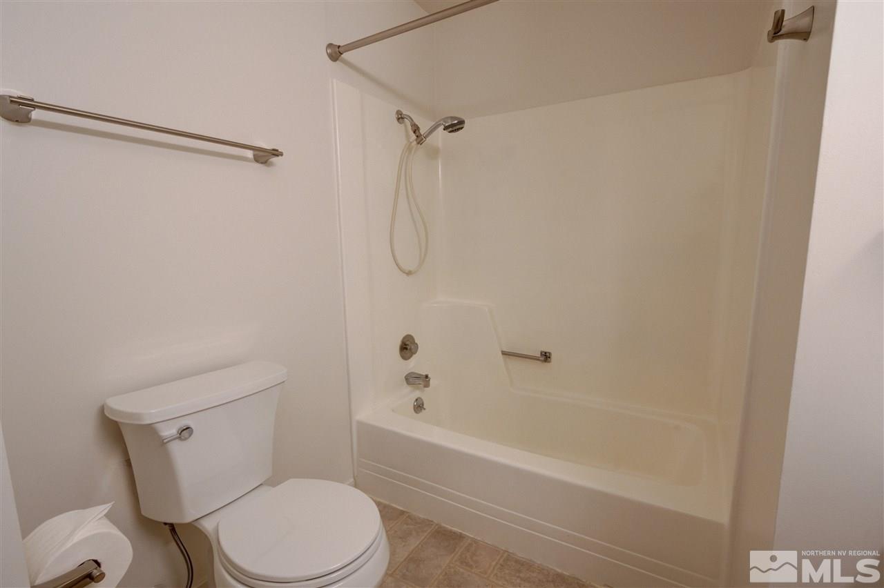 1221 Laredo Court Reno, NV 89503 - Photo 22 of 32 a white toilet and tub sitting next to a bathroom sink