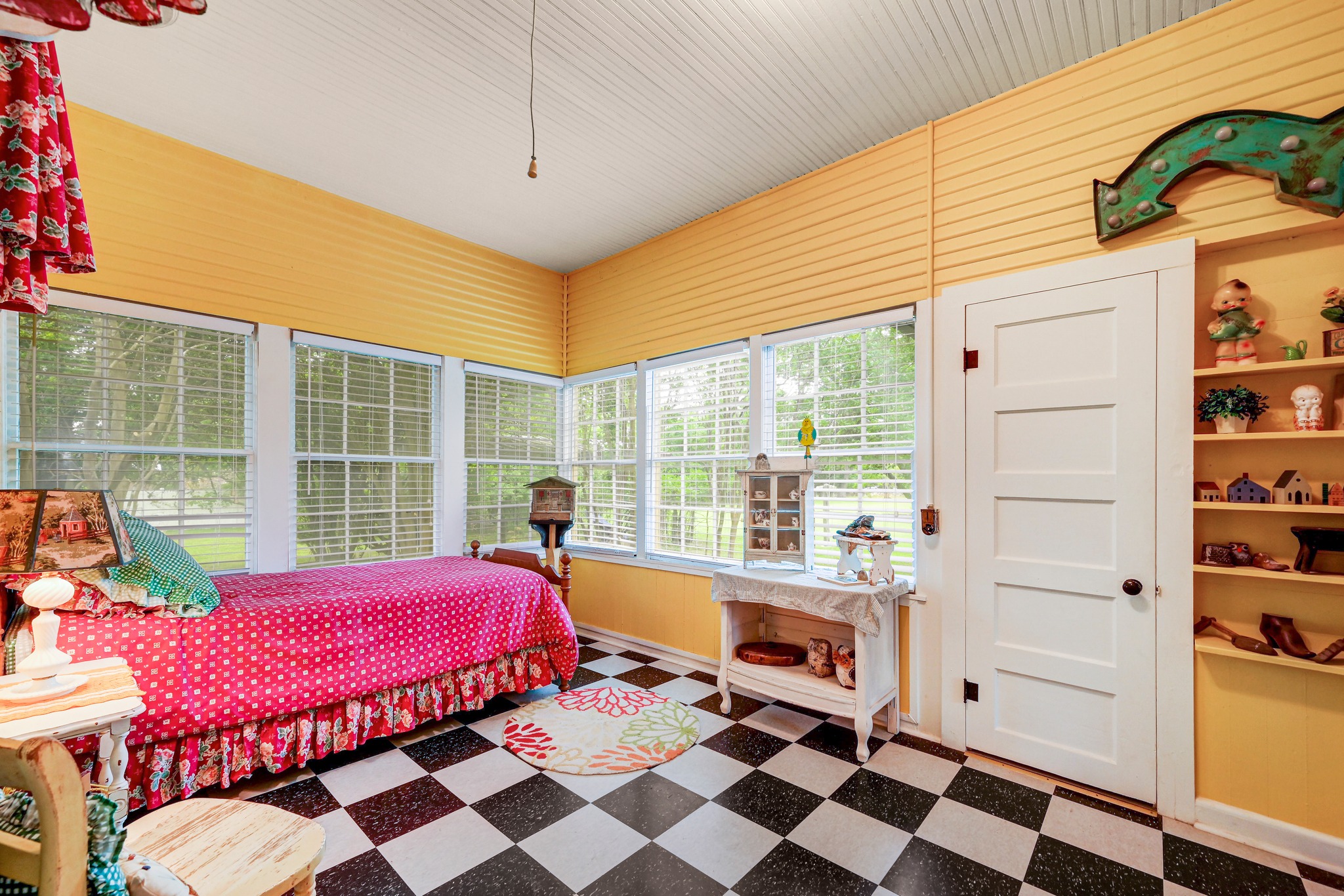 719 Elm Street Blanco, TX 78606 - Photo 15 of 25 Sunroom featuring checkerboard flooring, multiple windows with blinds, a paneled ceiling, built-in shelving, and a four-panel interior door