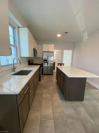 a large kitchen with a large counter top and stainless steel appliances