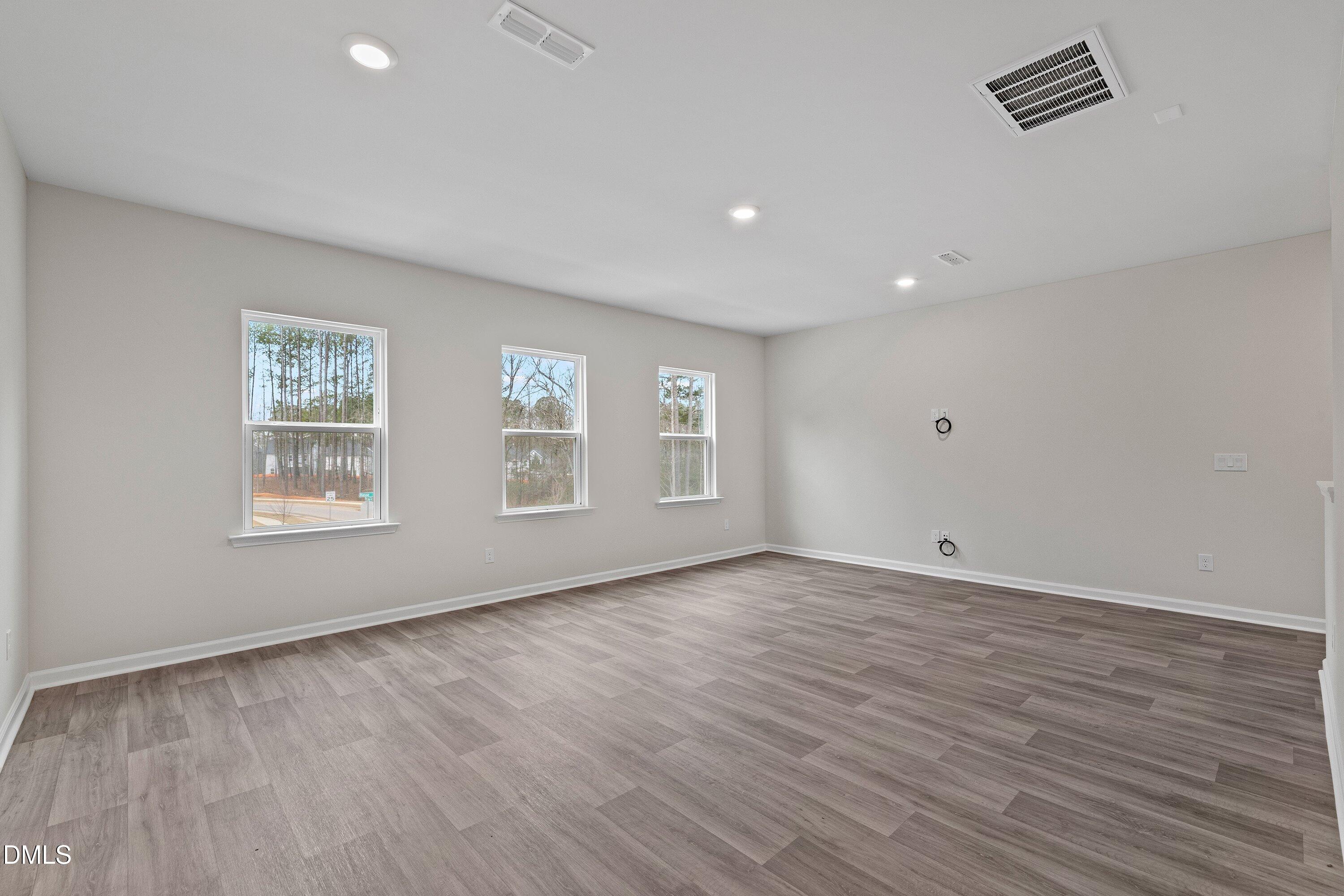 2550 Olive Chapel Road Apex, NC 27502 - Photo 22 of 41 a view of an empty room with wooden floor and a window