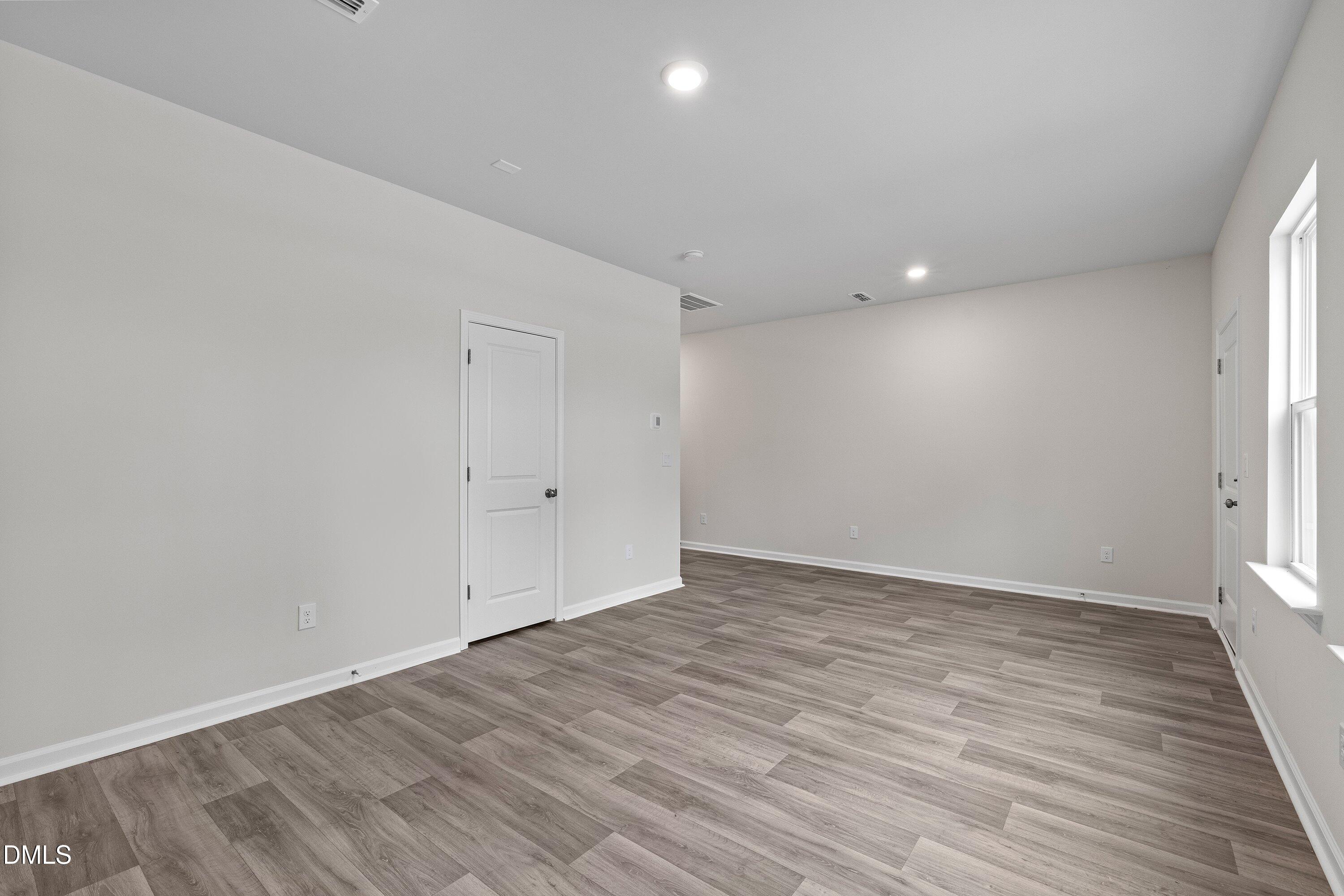 2550 Olive Chapel Road Apex, NC 27502 - Photo 6 of 41 a view of an empty room with wooden floor and a window