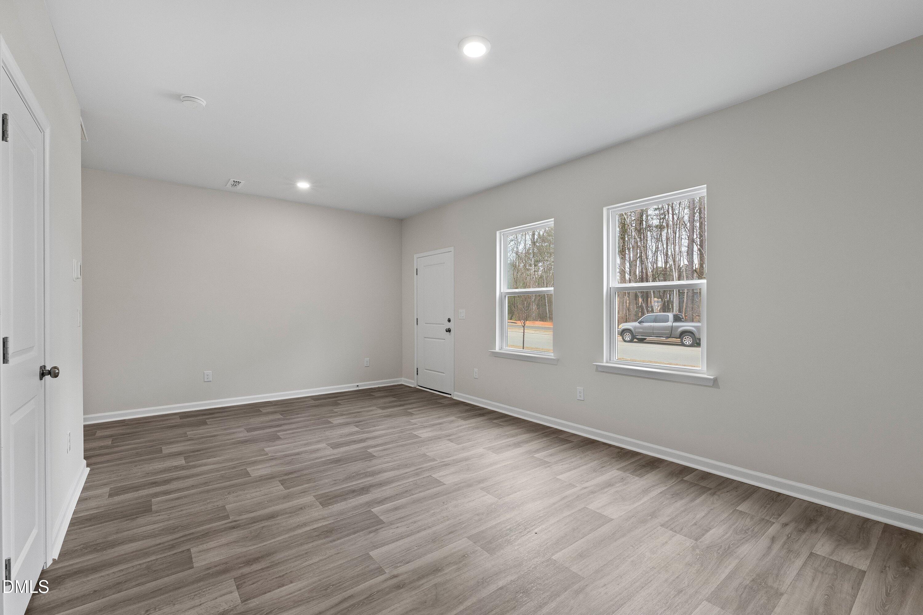 2550 Olive Chapel Road Apex, NC 27502 - Photo 7 of 41 an empty room with wooden floor and windows
