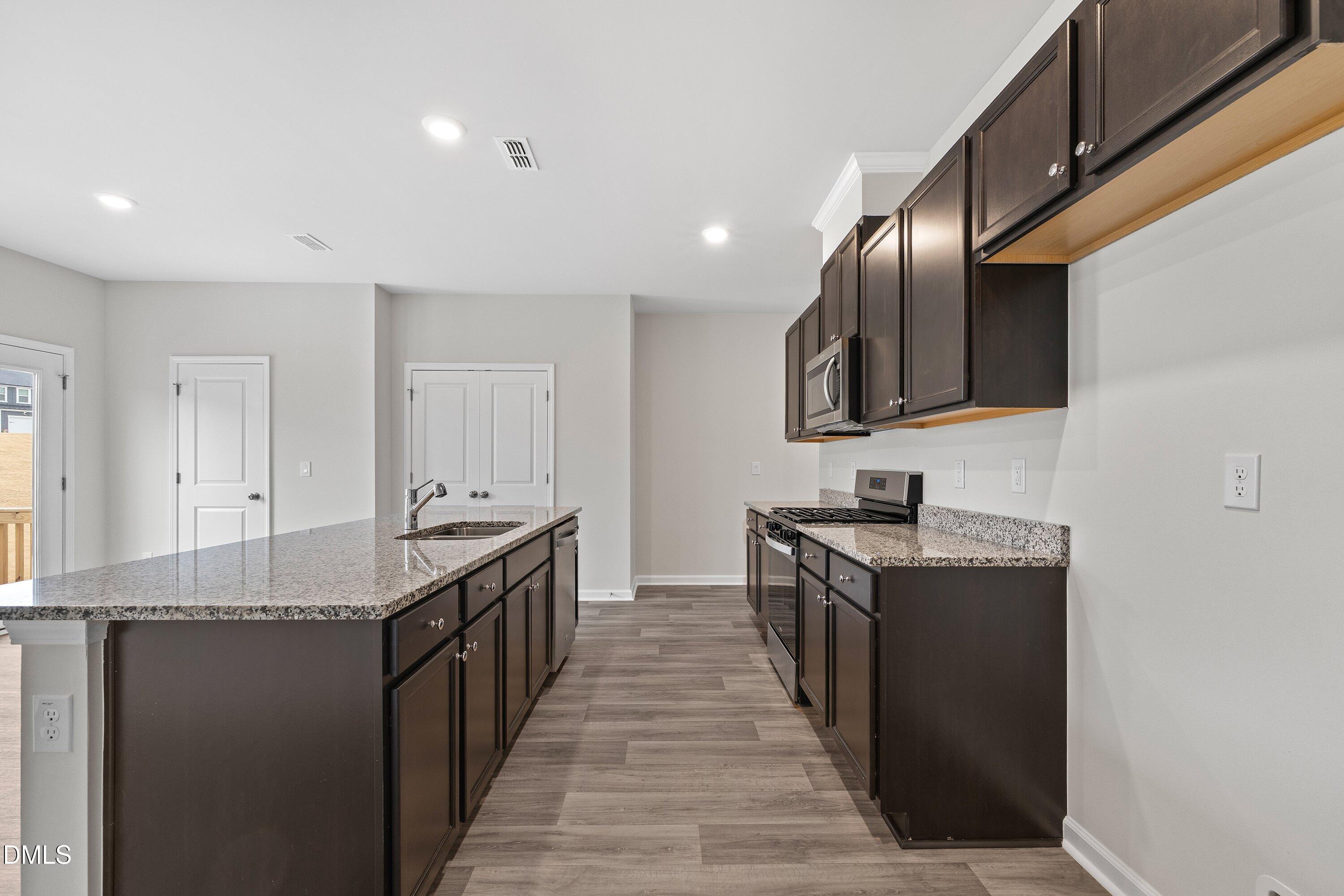 2550 Olive Chapel Road Apex, NC 27502 - Photo 8 of 41 a kitchen with stainless steel appliances granite countertop a sink and a stove