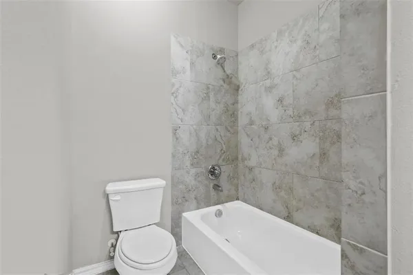 a white toilet sitting next to a bath tub