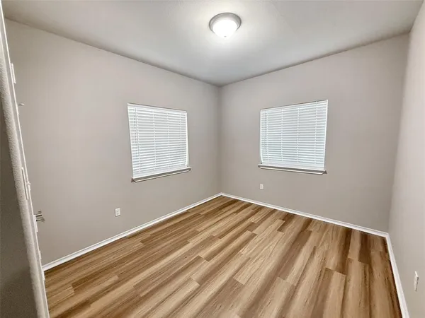 a view of an empty room with wooden floor