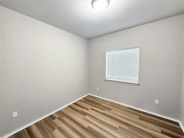 a view of a room with wooden floor and fan