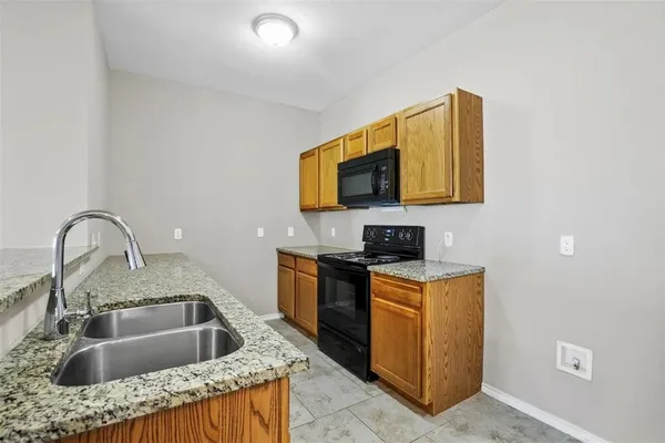 a kitchen with a sink a stove and a microwave