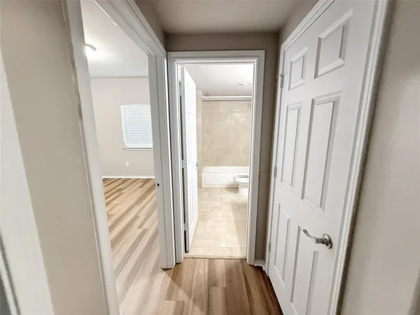 a view of a hallway with wooden floor and staircase