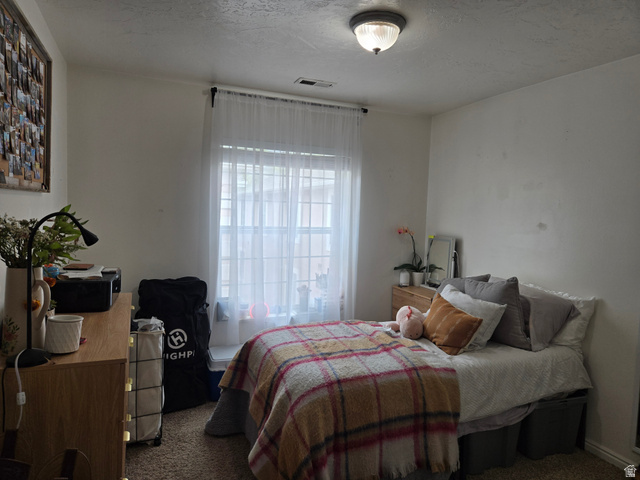 343 300 North, Unit 9 Provo, UT 84601 - Photo 9 of 10 Bedroom with dark colored carpet and a textured ceiling