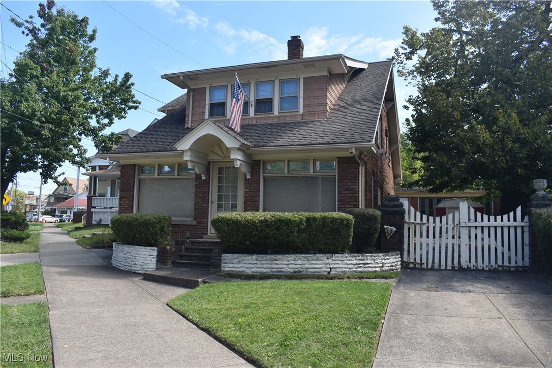 4581 Pearl Road Cleveland, OH 44109 - Photo 1 of 36 View of front of house with brick siding, a shingled roof, a chimney, and a front yard