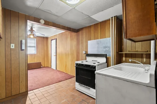 an empty room with a ceiling fan and a window