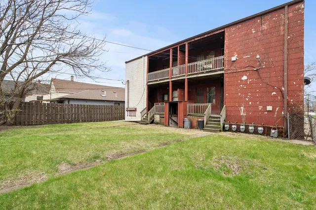 a view of a house with backyard and a tree