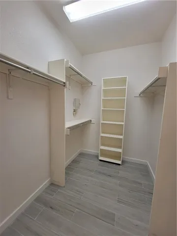 a view of walk in closet with empty racks