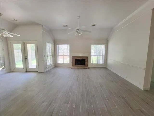 wooden floor fireplace and windows in an empty room