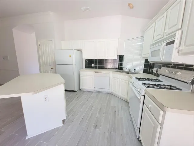 a kitchen with a stove a sink and a refrigerator