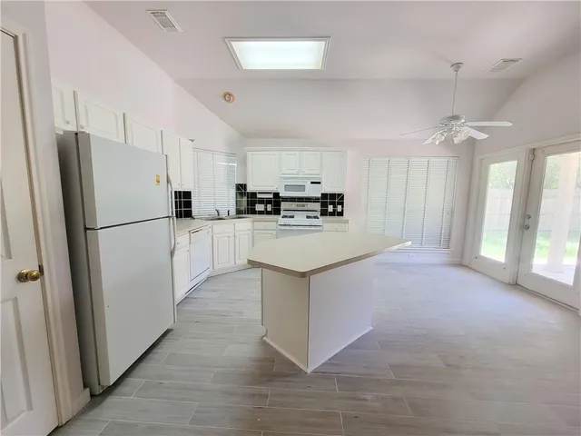 a kitchen with stainless steel appliances a refrigerator a sink a stove a microwave and island