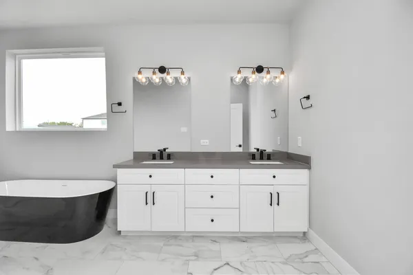 a bathroom with a double vanity sink a mirror and bathtub