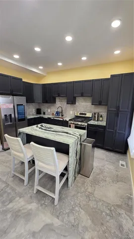 a kitchen with stainless steel appliances granite countertop a stove top oven a sink and a microwave