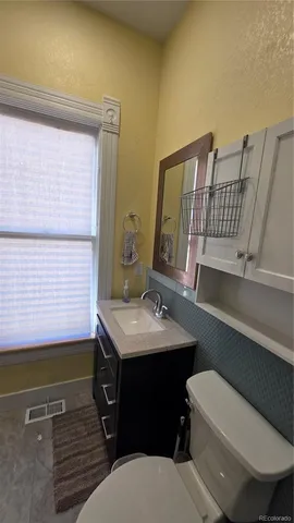 a bathroom with a sink a toilet and mirror