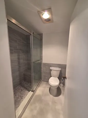 a bathroom with a toilet and a shower