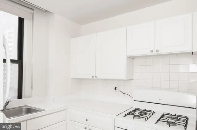 a kitchen with a white cabinets and a stove top oven