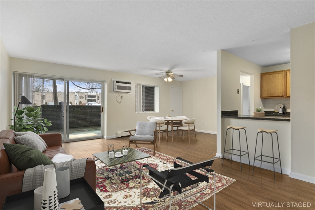 a living room with furniture a wooden floor and a large window