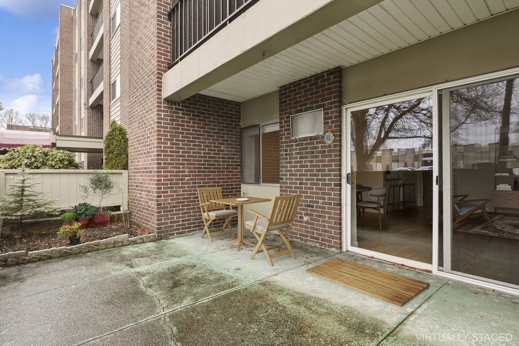 68 Main Street, Unit 17C Stoneham, MA 02180 - Photo 11 of 13 a view of a patio with table and chairs and potted plants