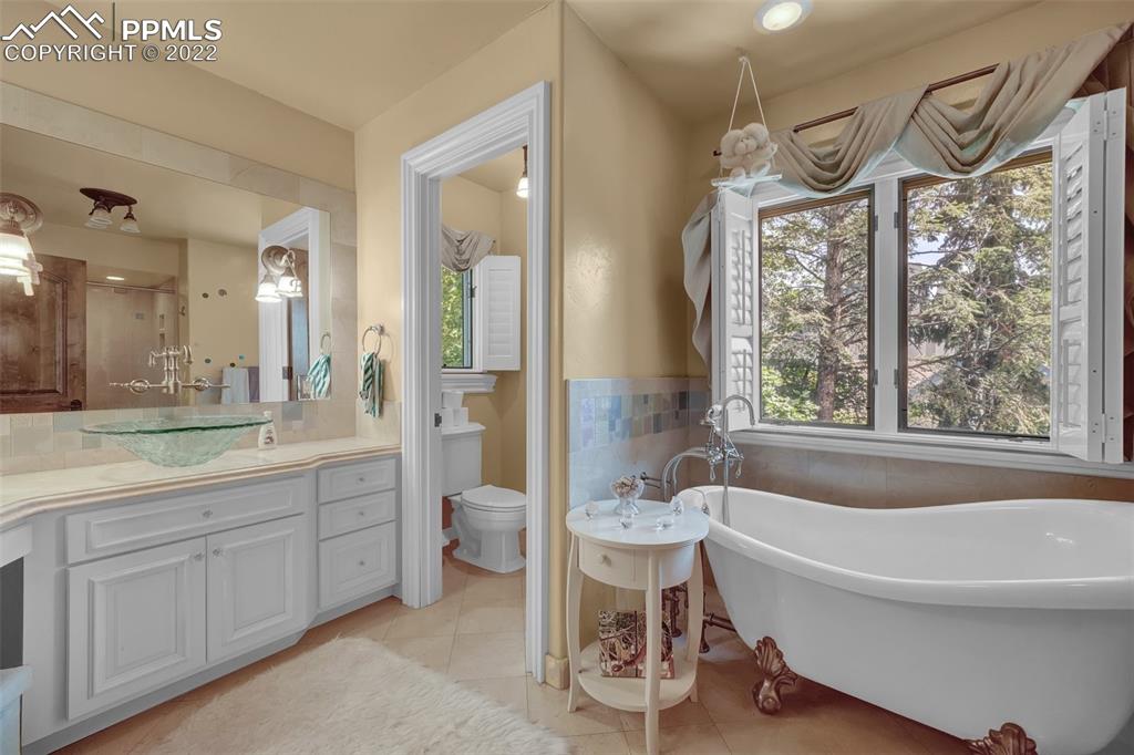 4 3rd Street Colorado Springs, CO 80906 - Photo 34 of 50 a spacious bathroom with a bathtub a sink and a large mirror