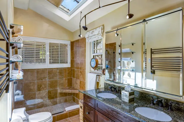 a bathroom with a granite countertop sink a mirror and shower