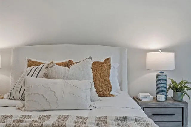 a bedroom with a large bed and a potted plant