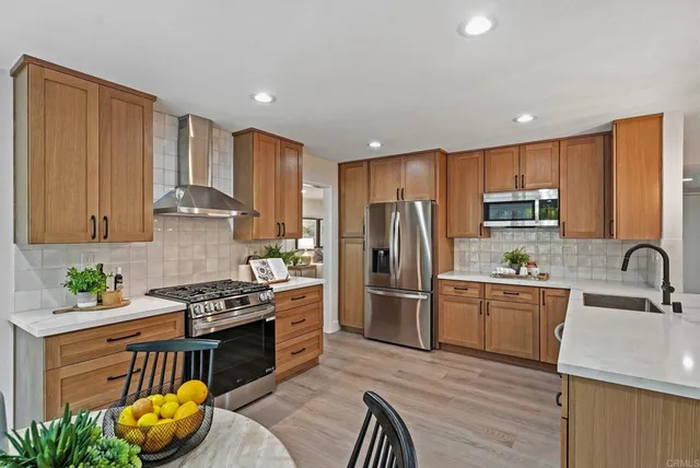 a kitchen with stainless steel appliances granite countertop a sink stove refrigerator and cabinets