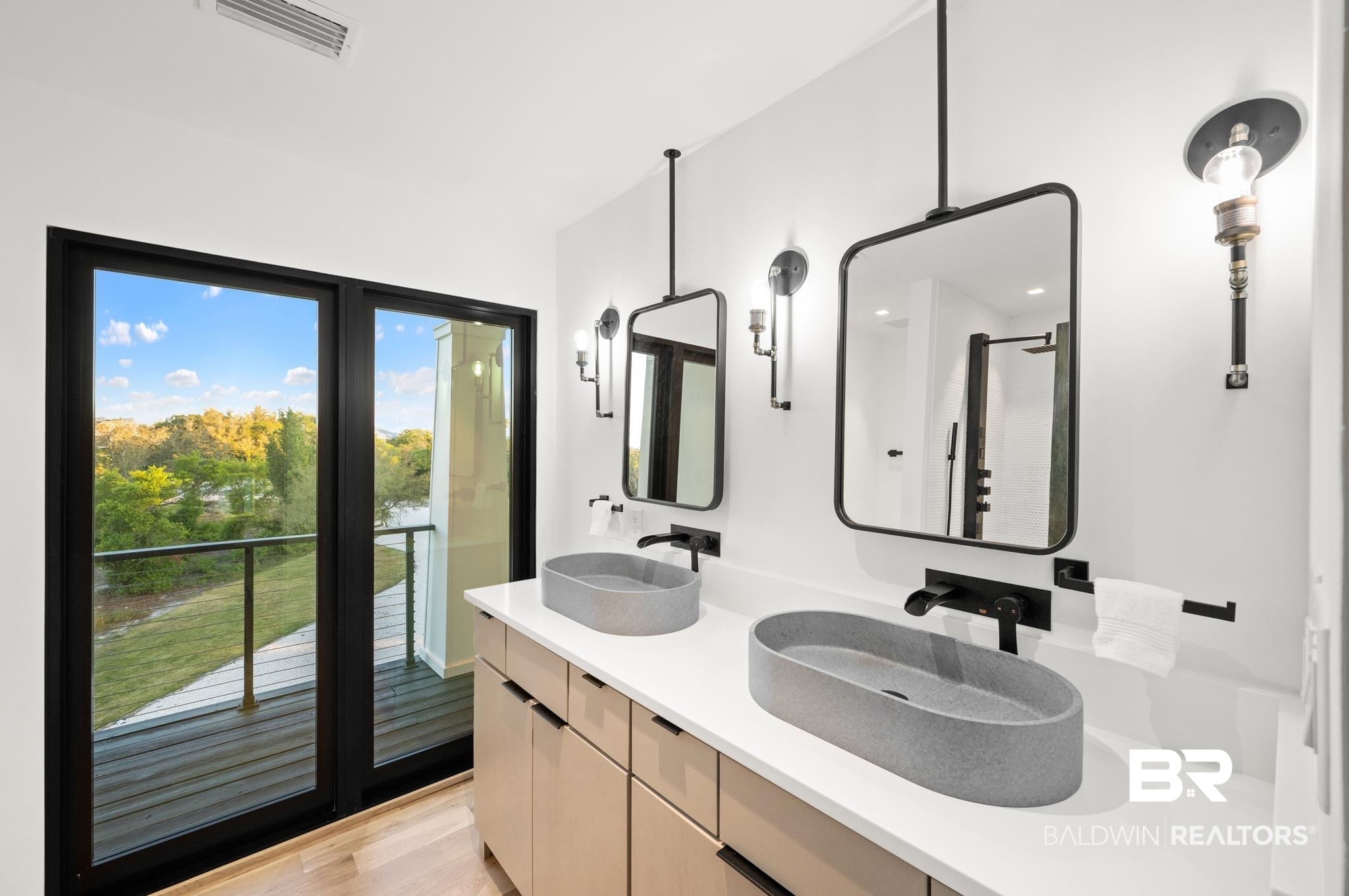 33349 River Road Orange Beach, AL 36561 - Photo 23 of 61 Dual vessel sinks set on a light-toned countertop, featuring individual wall-mounted faucets and framed mirrors