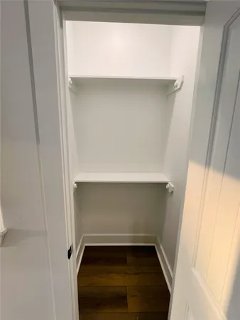 a view of a hallway with wooden floor and a window