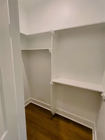 a room with a wooden floor and potted plant on the counter