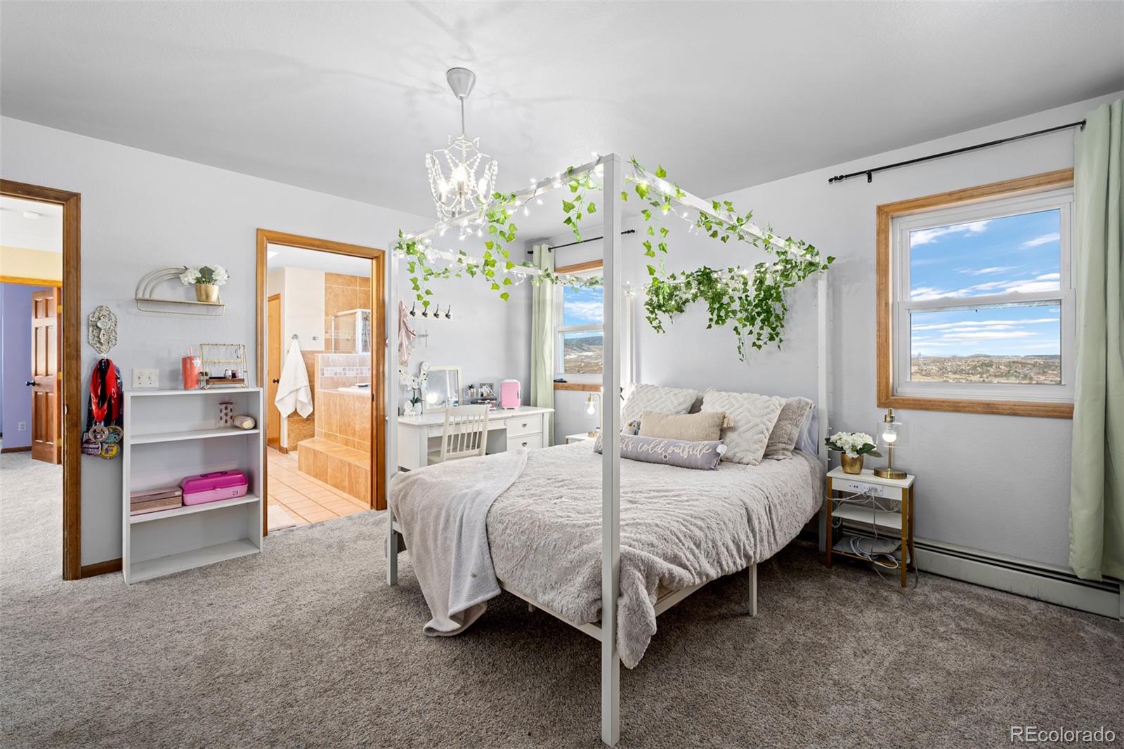 4205 West Parkridge Road Sedalia, CO 80135 - Photo 38 of 50 a bedroom with a bed and a chandelier