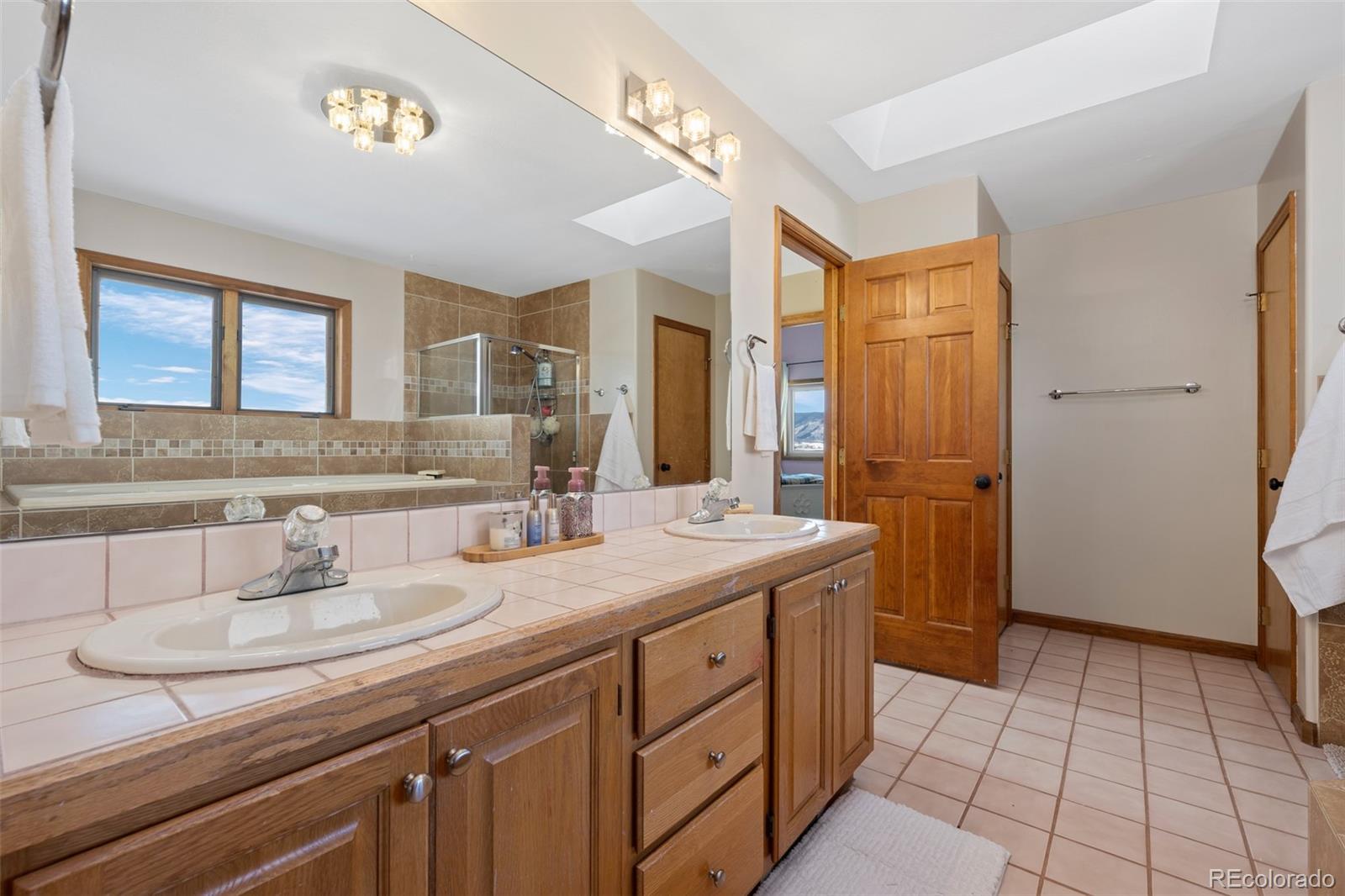 4205 West Parkridge Road Sedalia, CO 80135 - Photo 41 of 50 a bathroom with a sink a vanity a mirror and a toilet